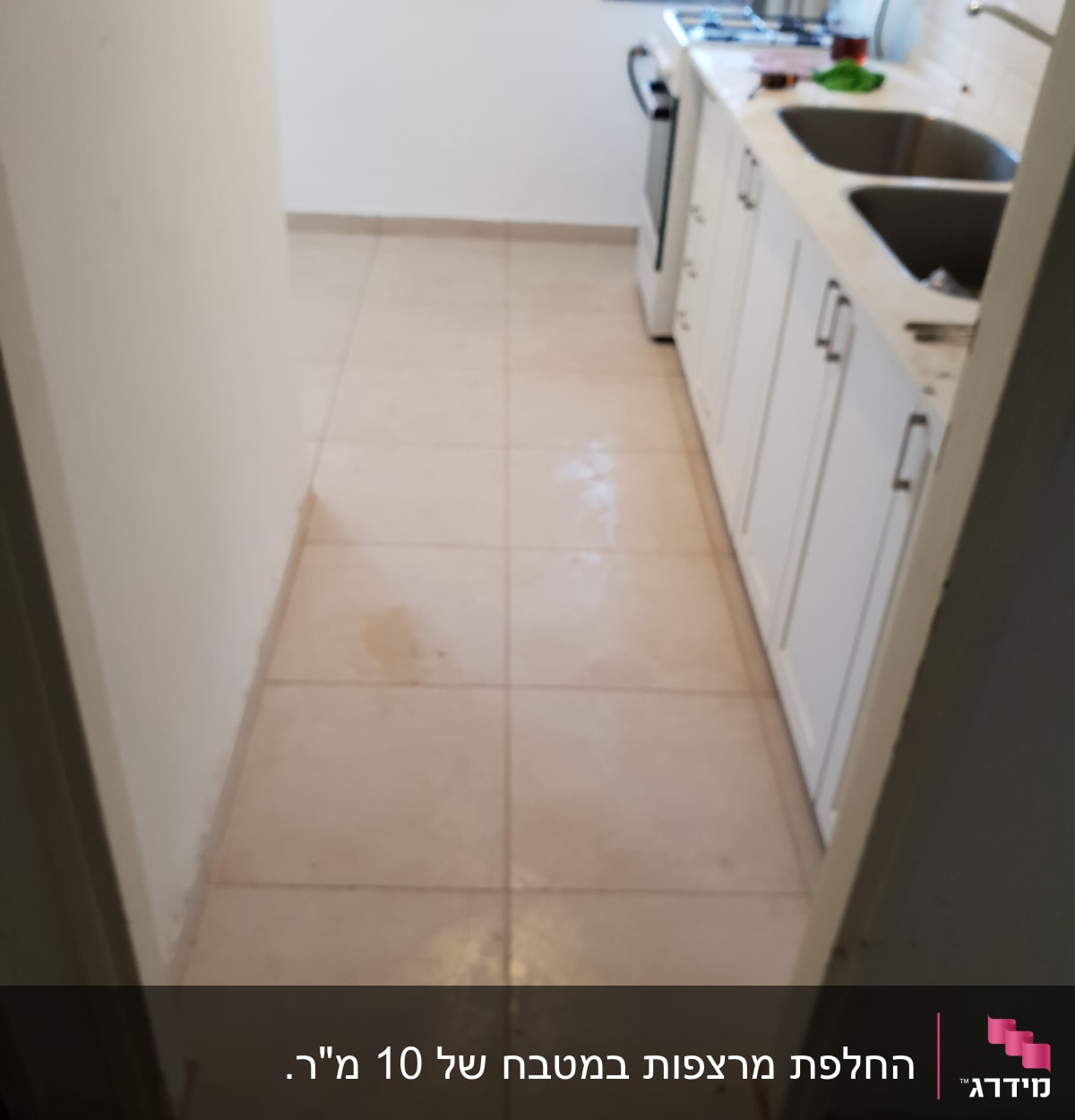 מטבח עם ארונות לבנים וכיור כפול